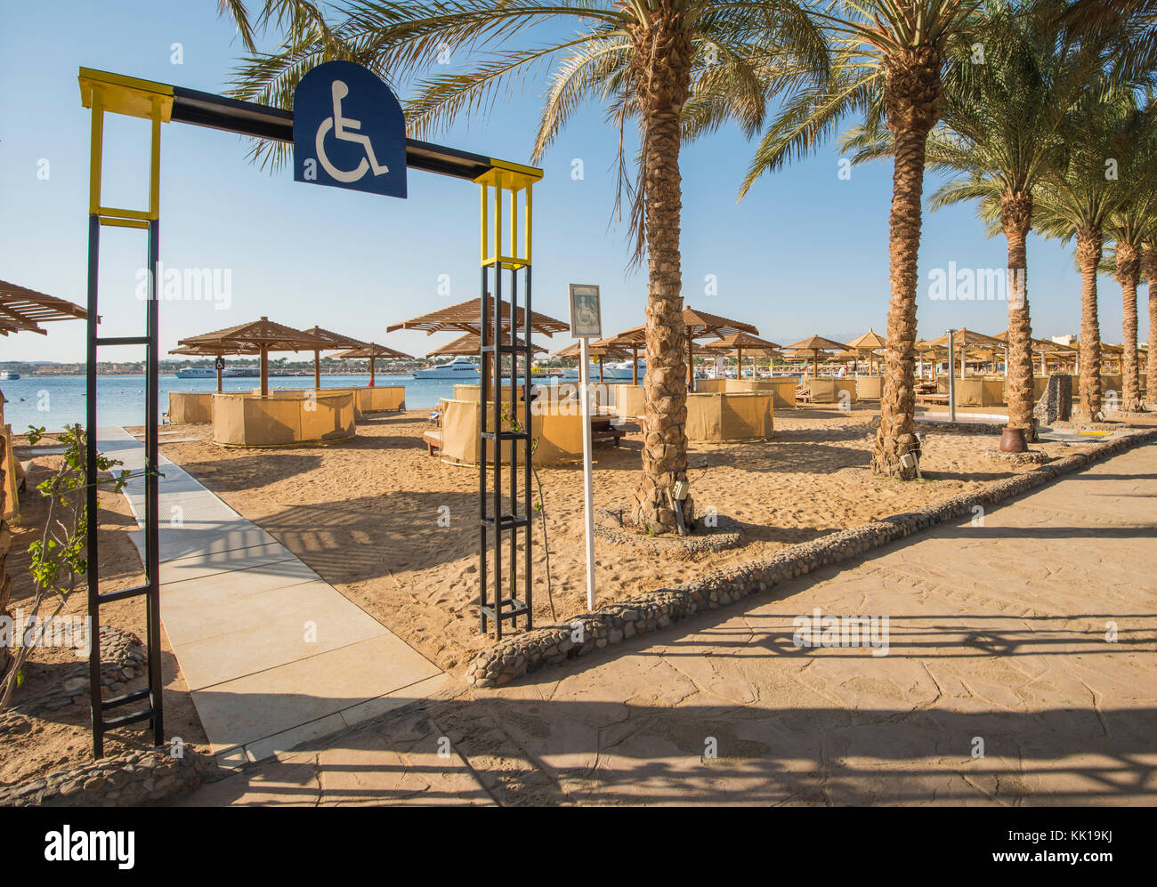Vista del paesaggio di una spiaggia di sabbia con accesso per disabili e lettini a lusso tropicale hotel resort Foto Stock