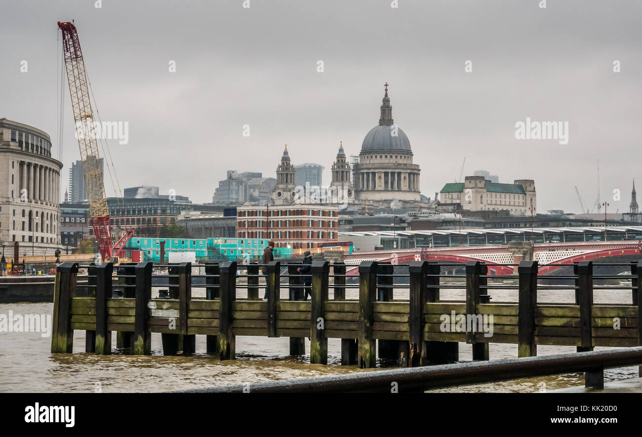 Il molo di legno sul fiume Tamigi con vista della Cattedrale di St Paul, Unilever House e Blackfriars Bridge di Londra, Inghilterra, Regno Unito, sul giorno opaco con cielo grigio Foto Stock