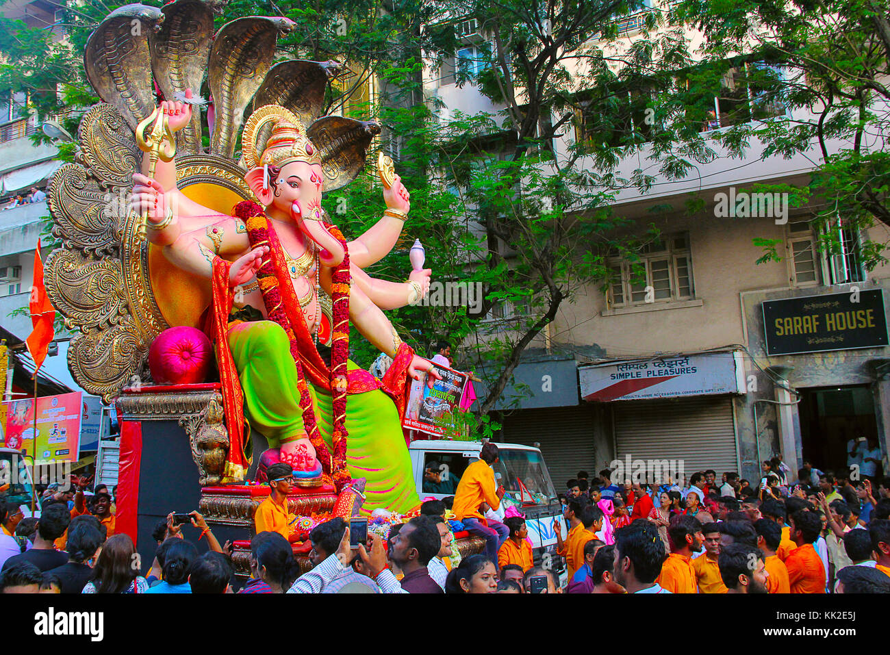 Enorme idolo Ganapati, decorato con teste serpenti trasportato su camion con devoti, Mumbai Foto Stock