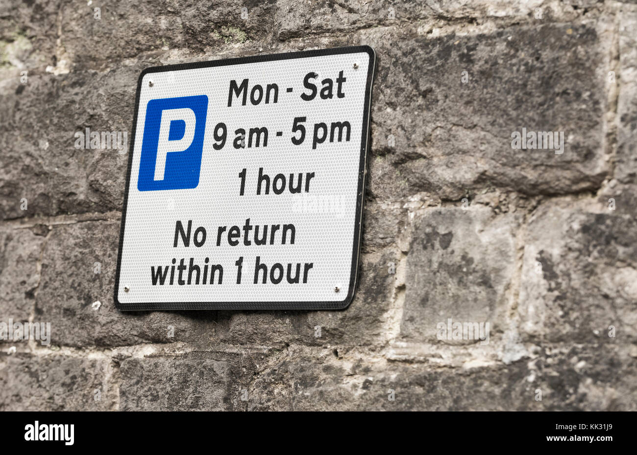 Parcheggio 'Nessun ritorno entro 1 ora segno montato su una parete nel Regno Unito. Foto Stock