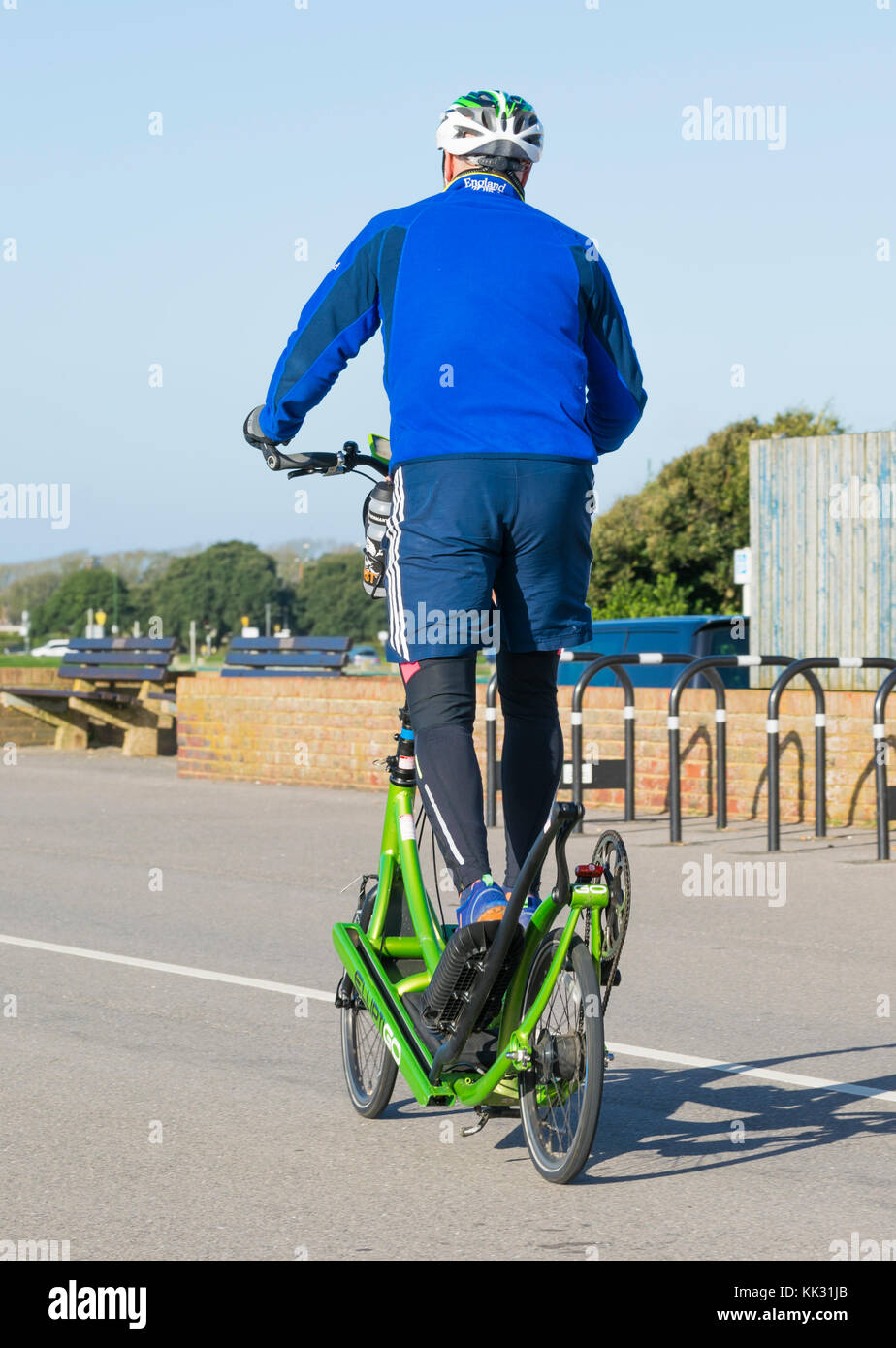 Uomo che cavalca un ElliptiGO bici ellittica NEL REGNO UNITO. Uomo in bicicletta su un Ellipti andare in bicicletta ellittica. Foto Stock