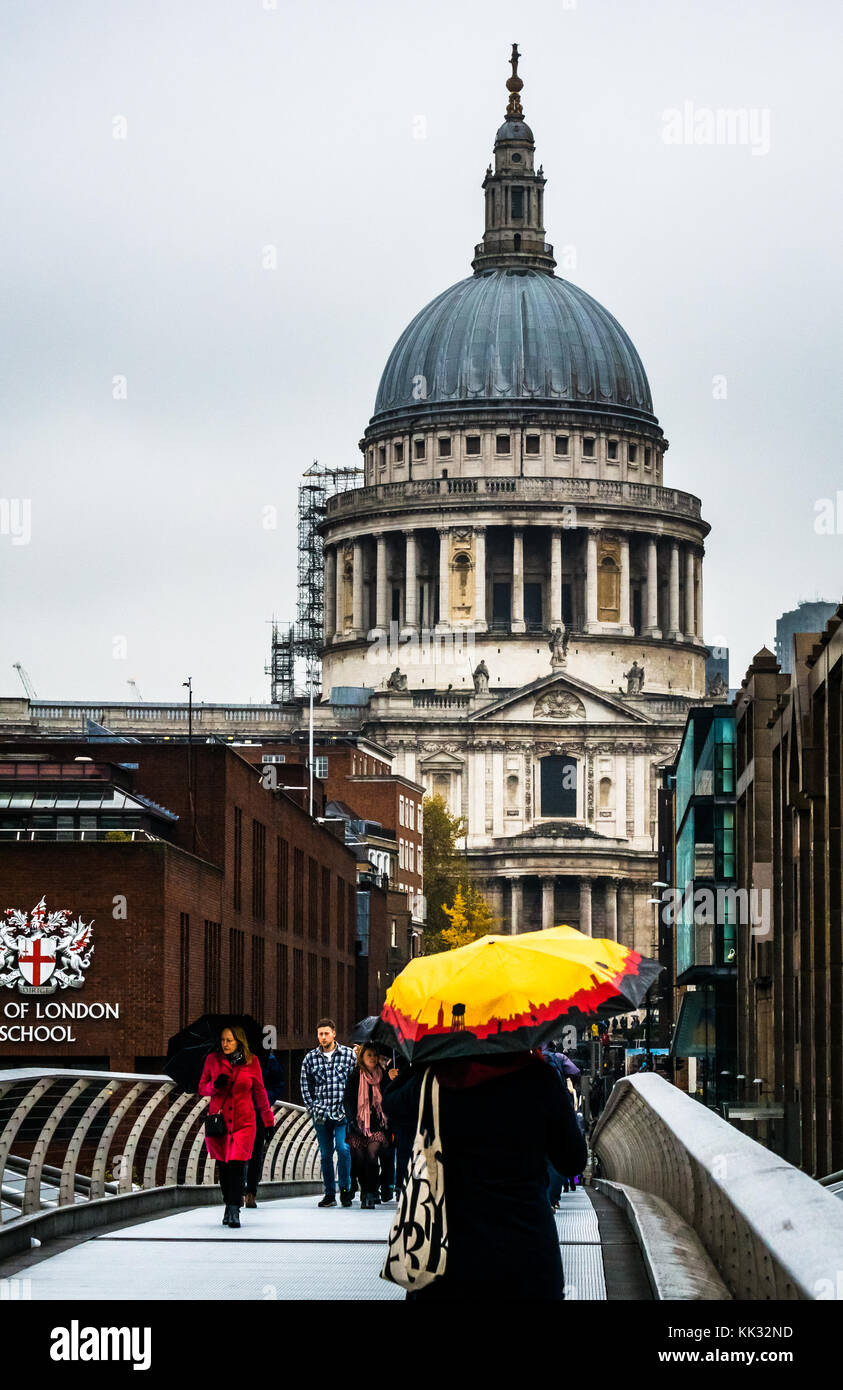 La gente che camminava sul Millennium Bridge sul giorno di pioggia con luminosi ombrelloni alla Cattedrale di St Paul e la City of London School, Thames, Inghilterra, Regno Unito Foto Stock