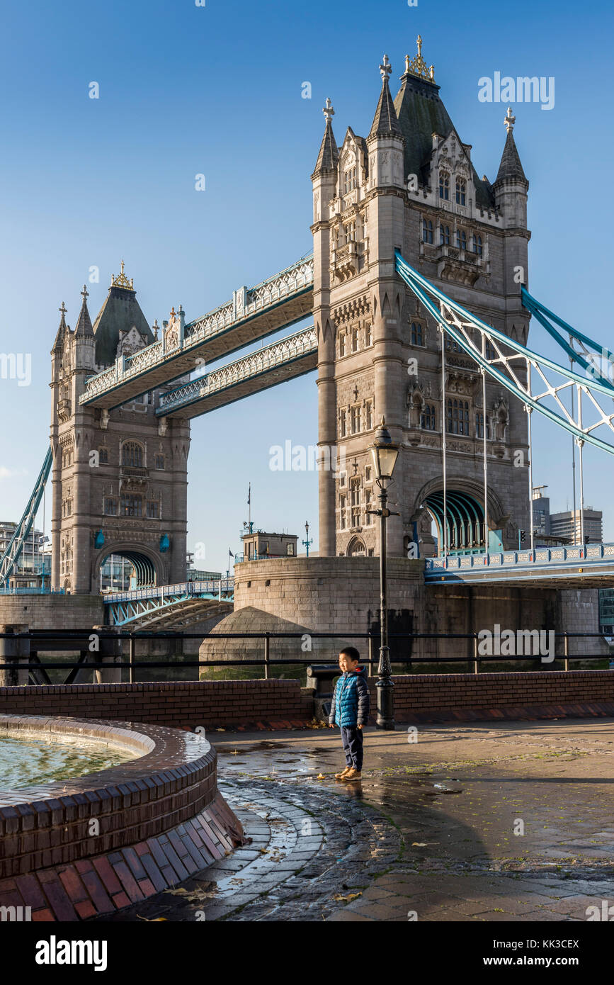 La giustapposizione di paesi dell Asia orientale boy vicino al Tower Bridge di Londra - Ingegneria vittoriano sul fiume Tamigi Foto Stock