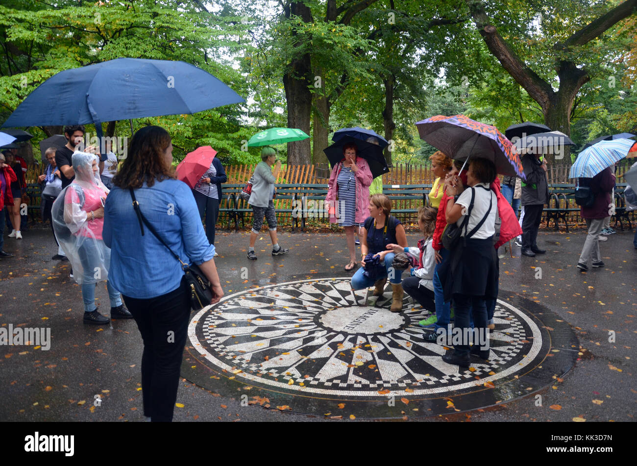 Turisti e appassionati pongono da Strawberry Fields memorial a mosaico in Central Park Foto Stock