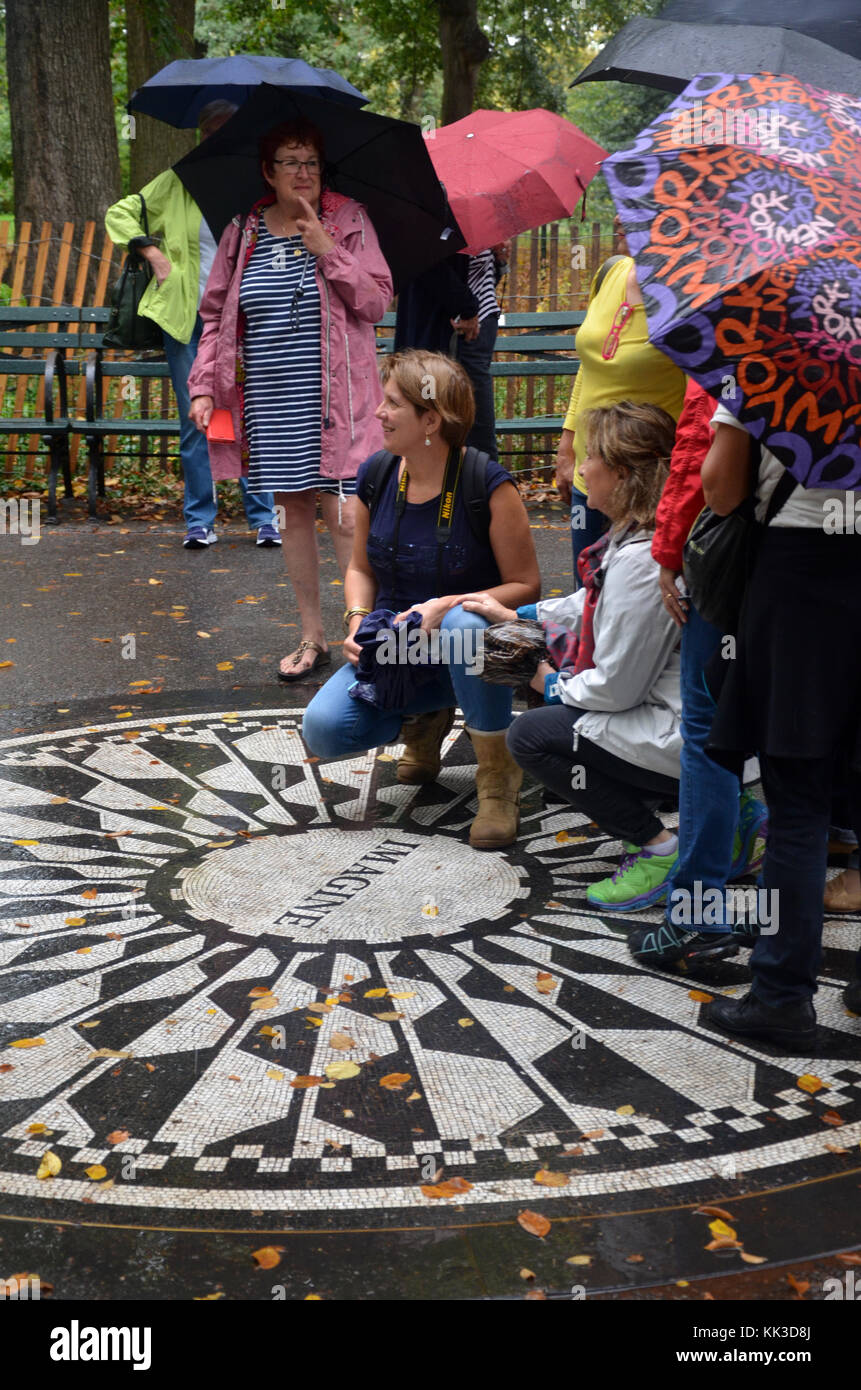 Turisti e appassionati pongono da Strawberry Fields memorial a mosaico in Central Park Foto Stock