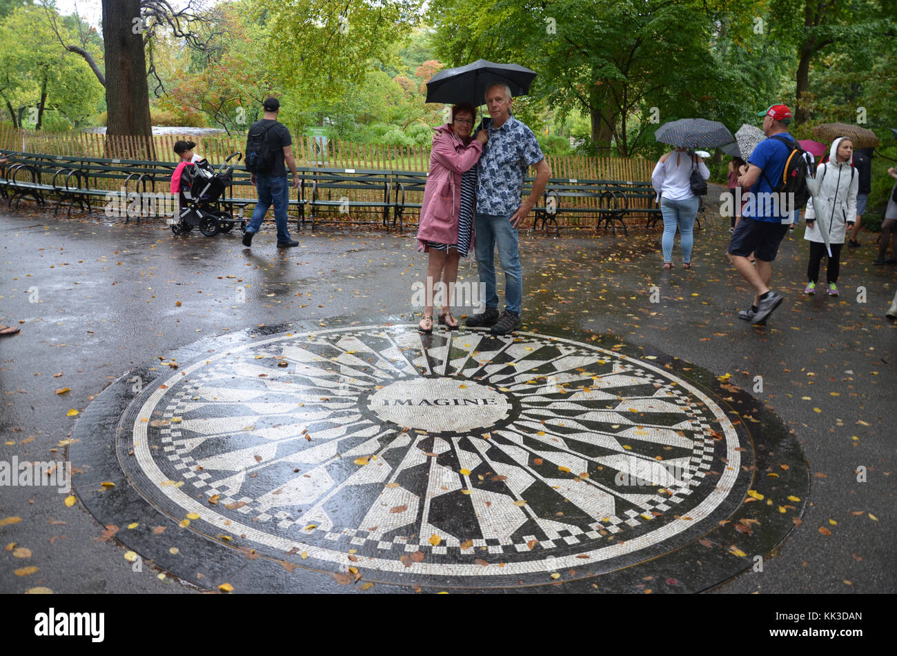 Turisti e appassionati pongono da Strawberry Fields memorial a mosaico in Central Park Foto Stock
