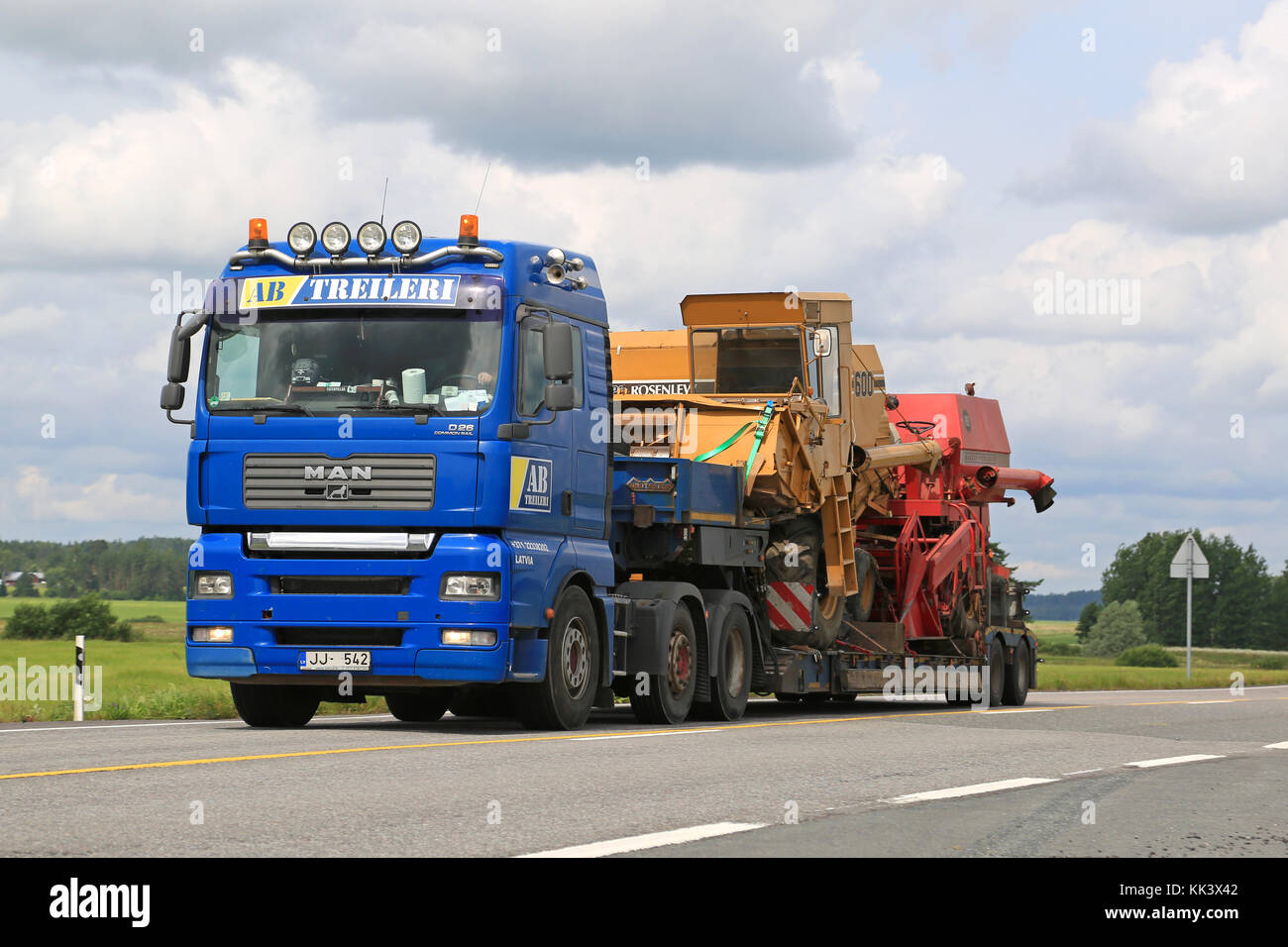 JOKIOINEN, FINLANDIA - 18 LUGLIO 2015: MAN Truck trasporta due mietitrebbia su un rimorchio a pianale ribassato. È necessario il permesso di trasporto anomalo, se presente Foto Stock