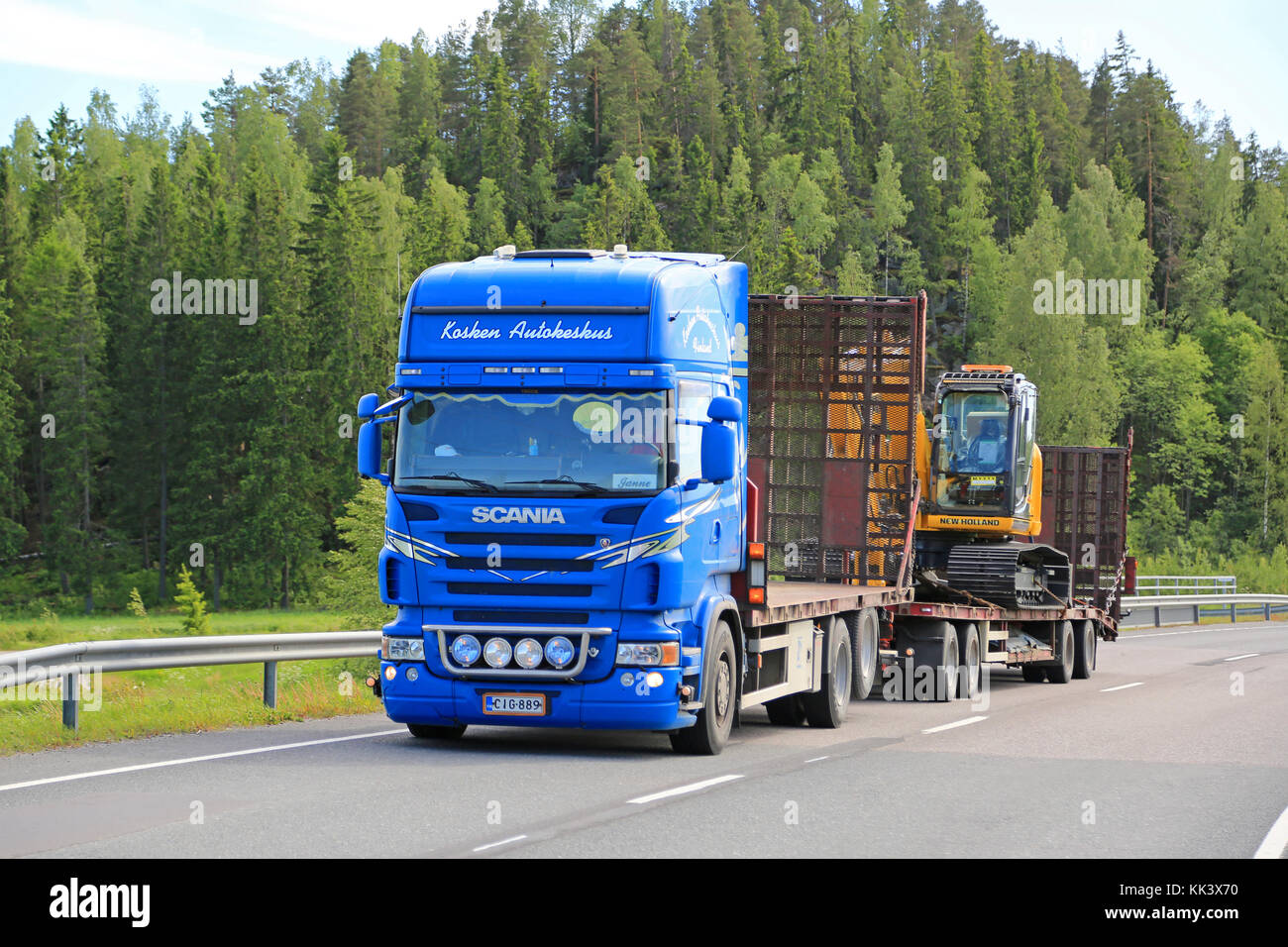 SALO, FINLANDIA - 12 GIUGNO 2015: Il veicolo industriale Blue Scania V8 trasporta l'escavatore cingolato New Holland. New Holland Construction produce tredici famiglie di prodotti. Foto Stock