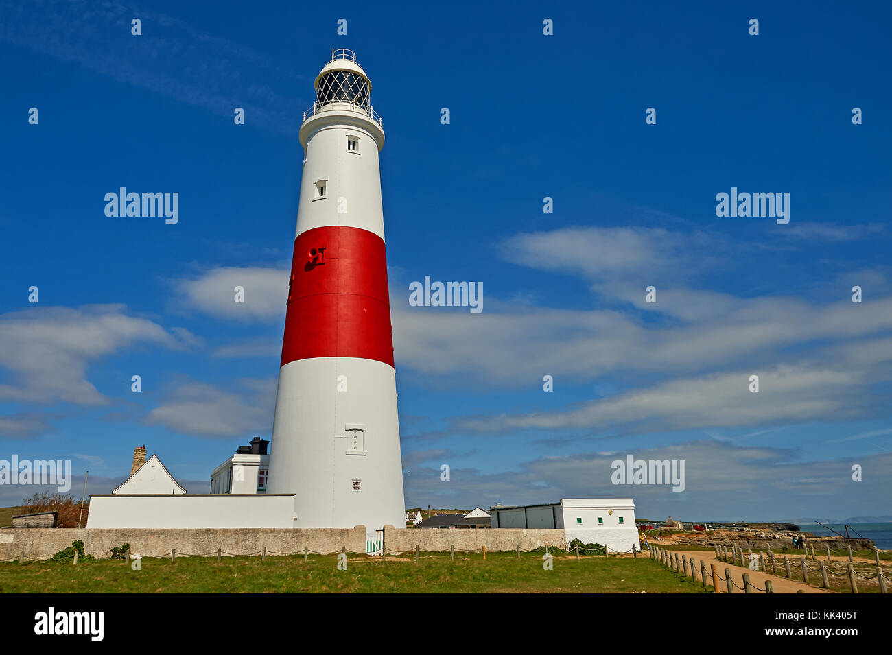 Portland Bill lighthouse in Dorset è un stereotipato della torre bianca con ampie striature rosso, visto contro un cielo blu. Foto Stock