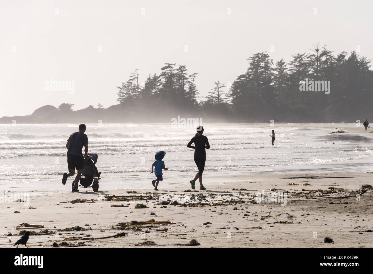 Chesterman Beach vicino a Tofino, BC, Canada (settembre 2017) - Famiglia che corre sulla sabbia. Foto Stock