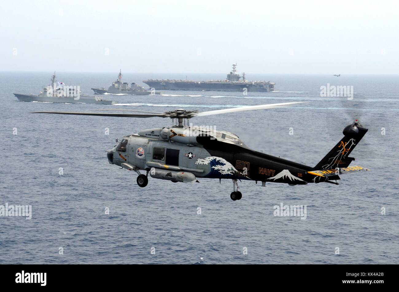 Un elicottero SH-60F Seahawk, assegnato al Chargers of Helicopter Anti-Submarine Squadron HS 14, è in volo mentre la portaerei USS George Washington CVN 73, il cacciatorpediniere JS Kirishima DD 174 della Japan Maritime Self-Defense Force, e il cacciatorpediniere della Marina della Repubblica di Corea ROKS Sejong il grande DDG 991 partecipa ad un evento trilaterale, Mar Cinese Orientale, 2012. Immagine gentilmente concessa da Mass Communication Specialist 1st Class Jennifer A. Villalovos/US Navy. Foto Stock