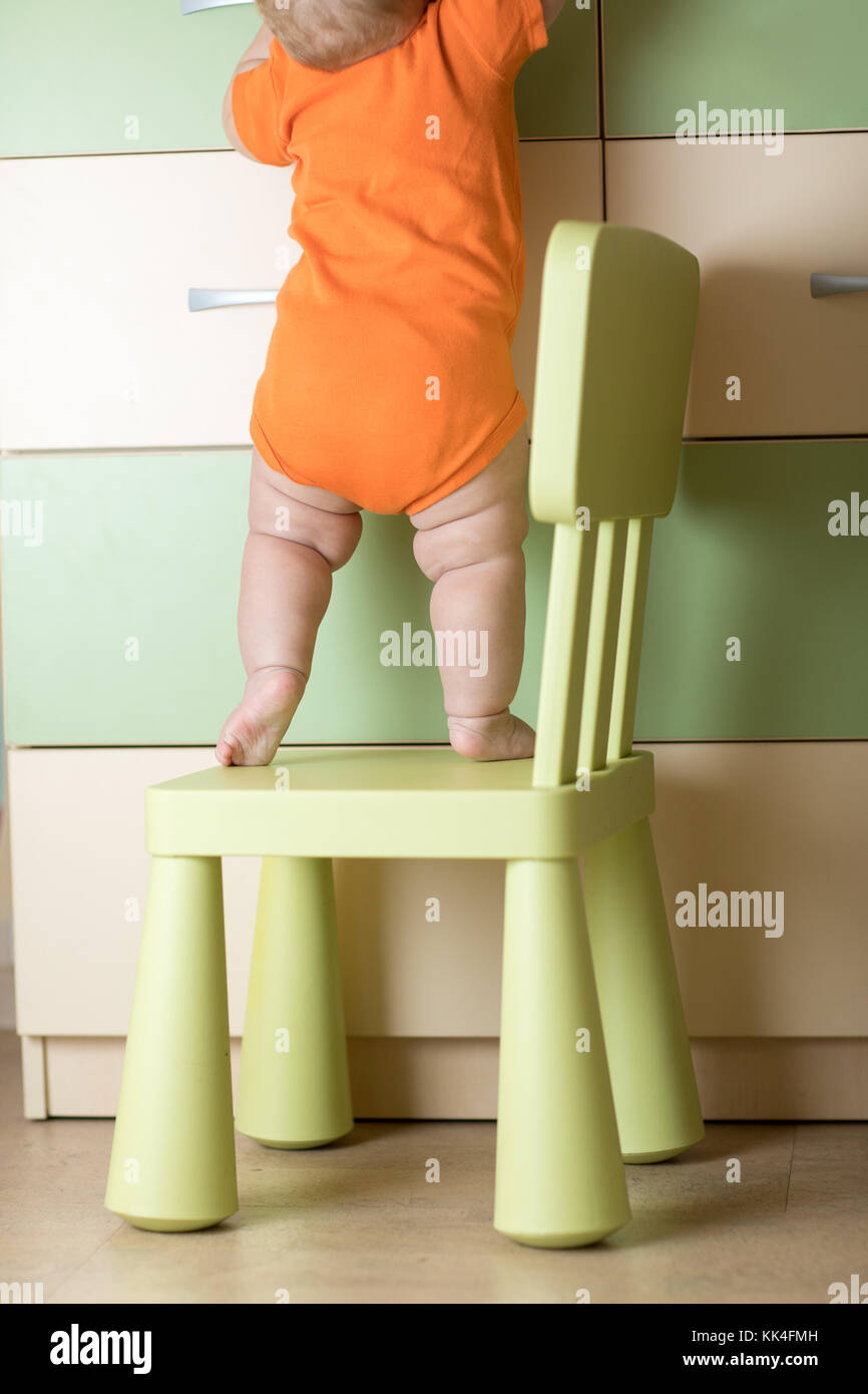 Baby arrampicata sulla sedia. kids safety concezione. Foto Stock