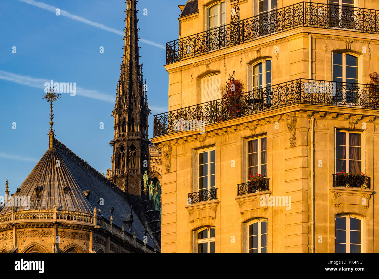 Edificio in stile haussmanniano, facciata al tramonto e la guglia di Notre Dame de Paris. Ile de la Cite, 4th Arrondissement, Parigi, Francia Foto Stock