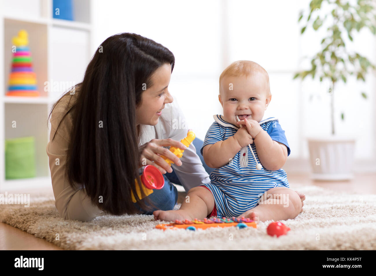 Mamma e Bambino giocare giocattoli musicali a casa Foto Stock