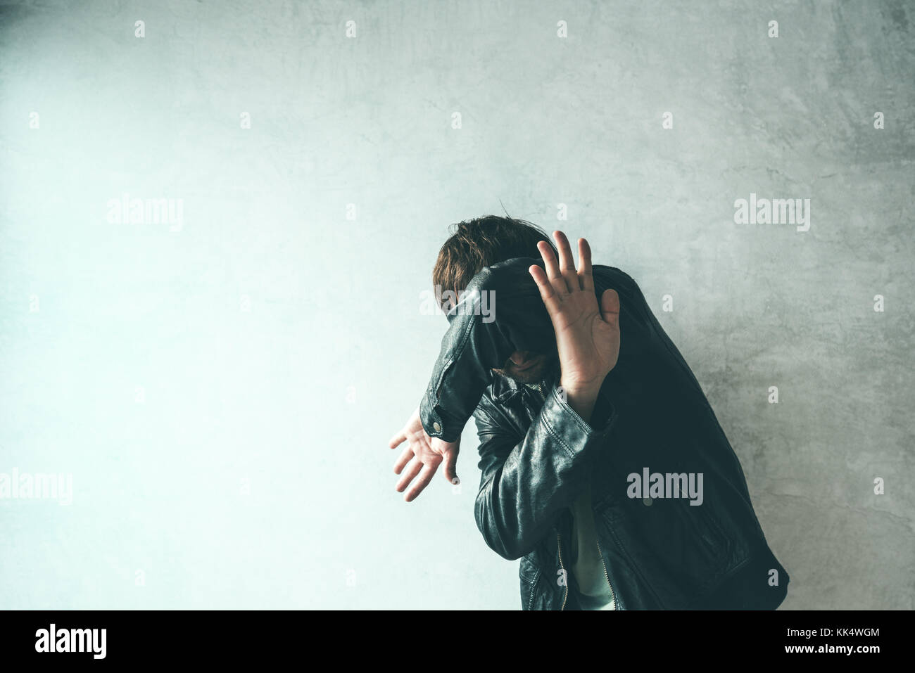 Maschio faccia di protezione da attacchi violenti. adulto uomo caucasico che ricopre la faccia e la testa per fermare i punzoni in una lotta da un utente malintenzionato. la violenza e la criminalità conc Foto Stock