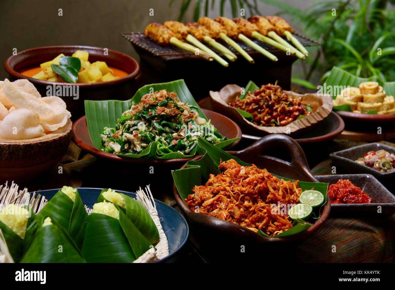 Balinese. buffet assortita di lato balinese piatti serviti in stile buffet; su una tavola rivestita con il tradizionale design balinese seseh tessuto tessile. Foto Stock