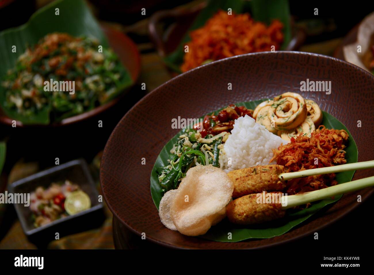 Il Nasi Campur Bali. Popolare il riso Balinesi piatto di riso al vapore con assortimento di piatti laterali, serviti insieme su una piastra. Foto Stock