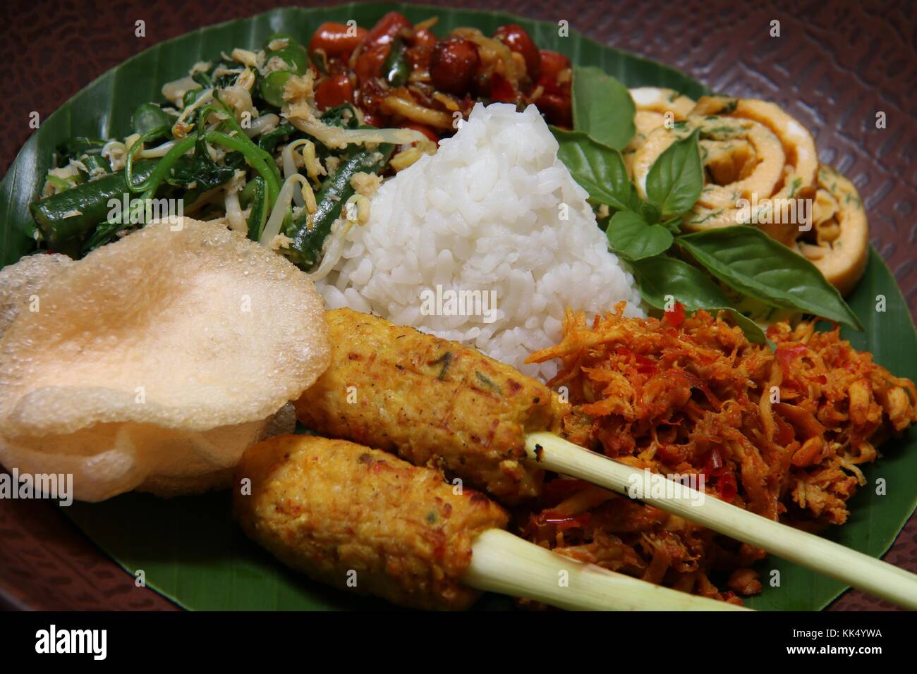 Il Nasi Campur Bali. Popolare il riso Balinesi piatto di riso al vapore con assortimento di piatti laterali, serviti insieme su una piastra. Foto Stock