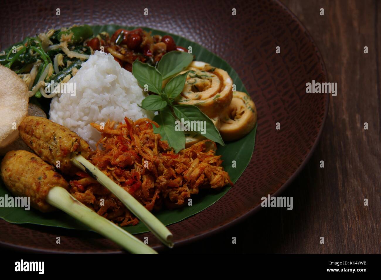 Il Nasi Campur Bali. Popolare il riso Balinesi piatto di riso al vapore con assortimento di piatti laterali, serviti insieme su una piastra. Foto Stock