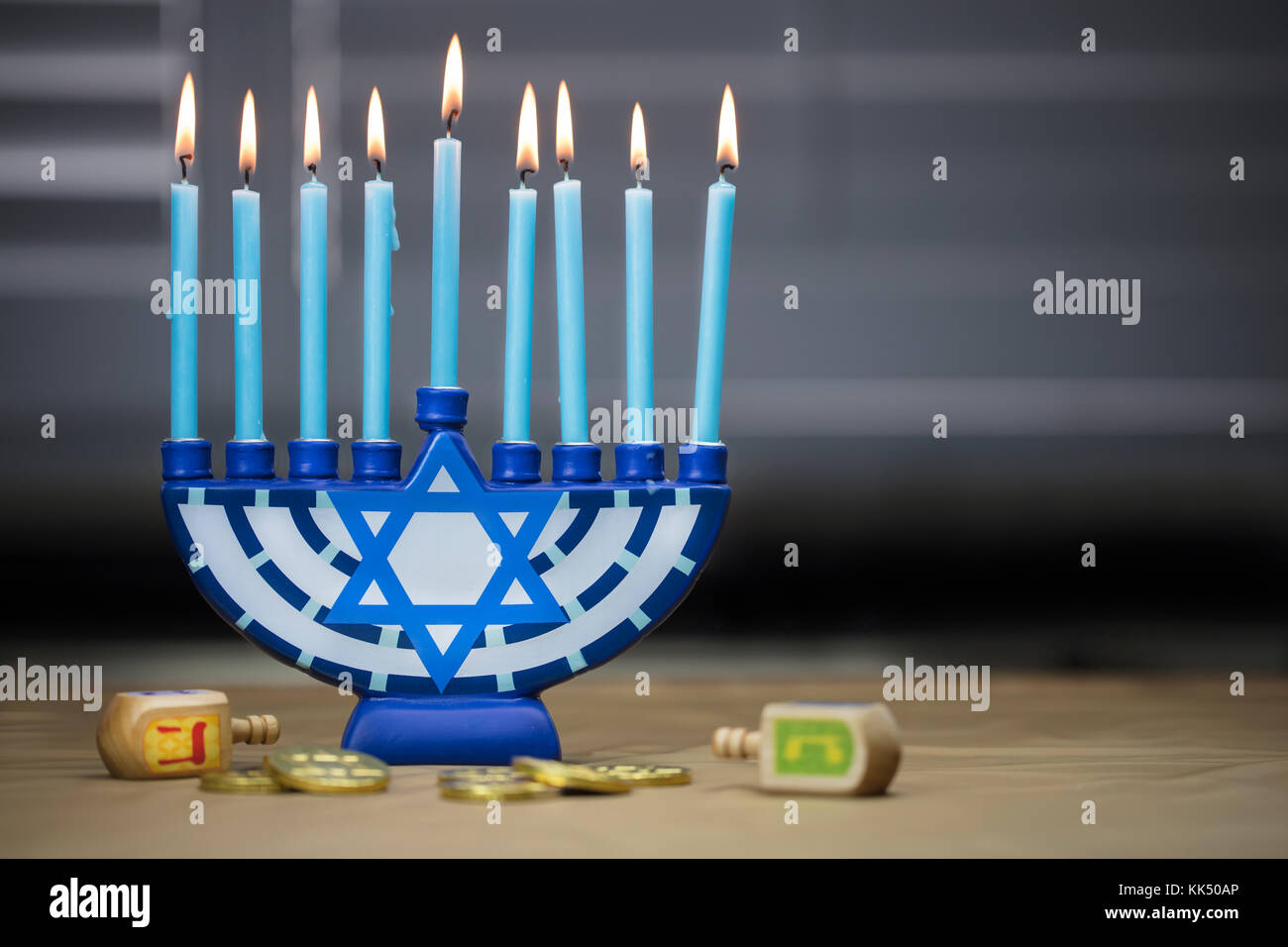 Hanukkah candele accese per la celebrazione di vacanza circondato da dreidels e monete di cioccolato Foto Stock