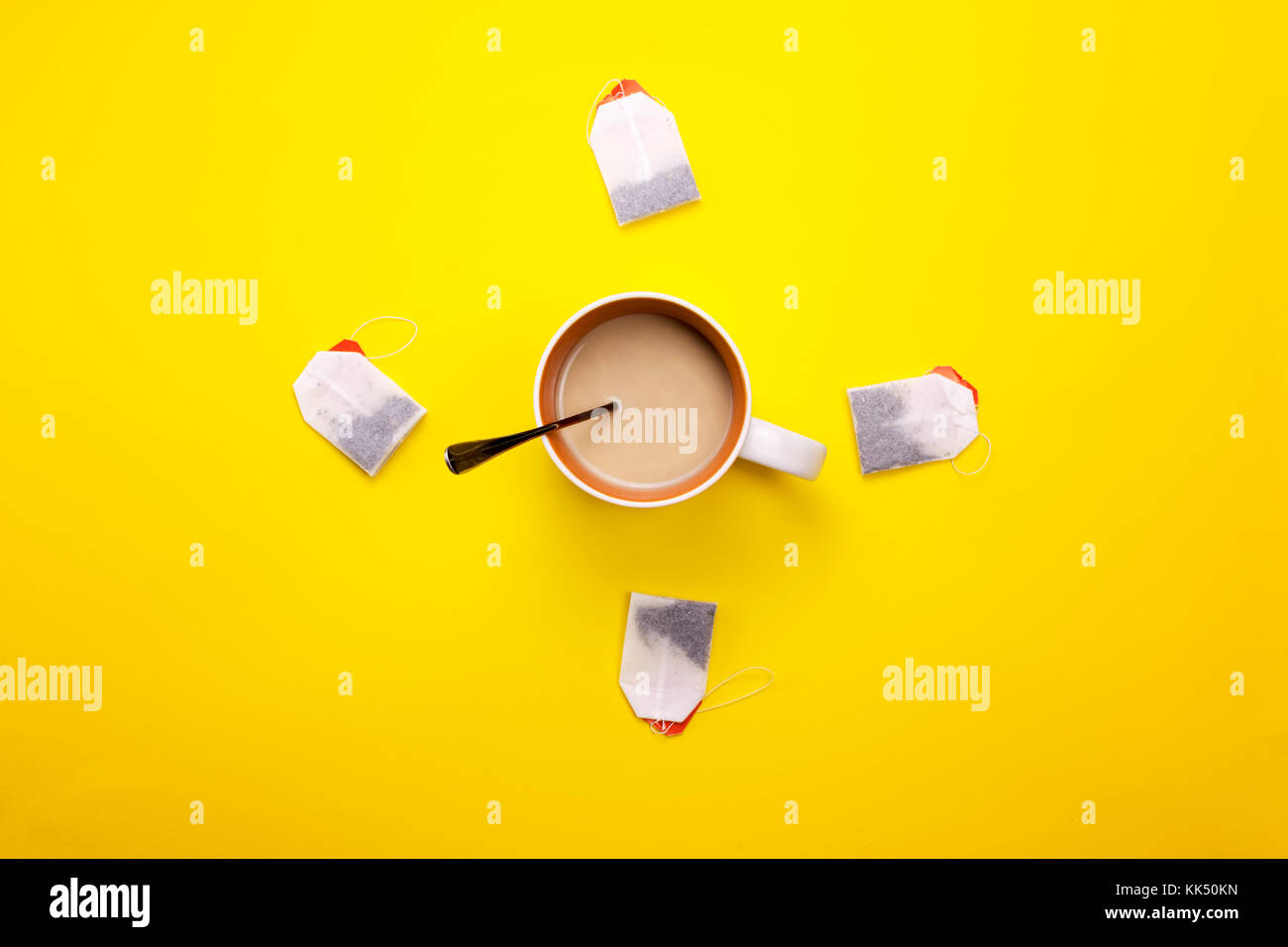 Tazza di caffè e bustine di tè intorno su uno sfondo colorato Foto Stock