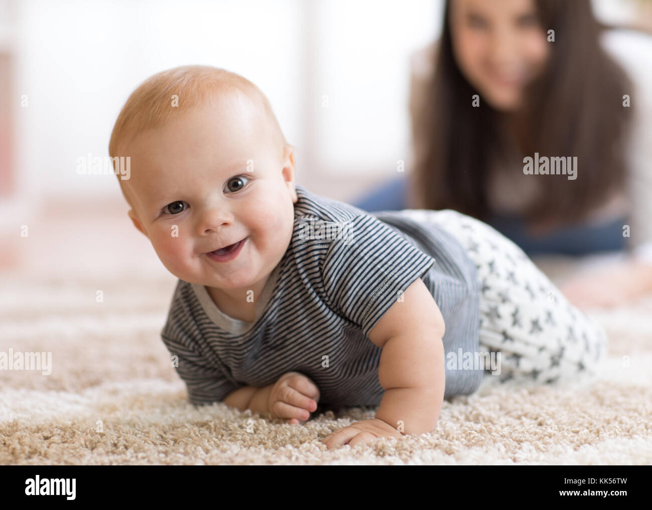 La madre gioca con lo spunto da fermi sul pavimento baby Foto Stock