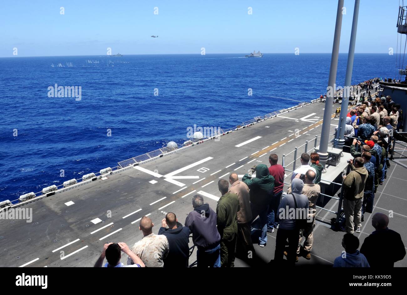 I marinai e i marines, i loro amici e familiari, assistono a uno spettacolo aereo dai ponti meteorologici a bordo della nave d'assalto anfibia USS Makin Island LHD 8, Oceano Pacifico, 2012. Per gentile concessione di Mass Communication Specialist Seaman Daniel J. Walls/US Navy. Foto Stock