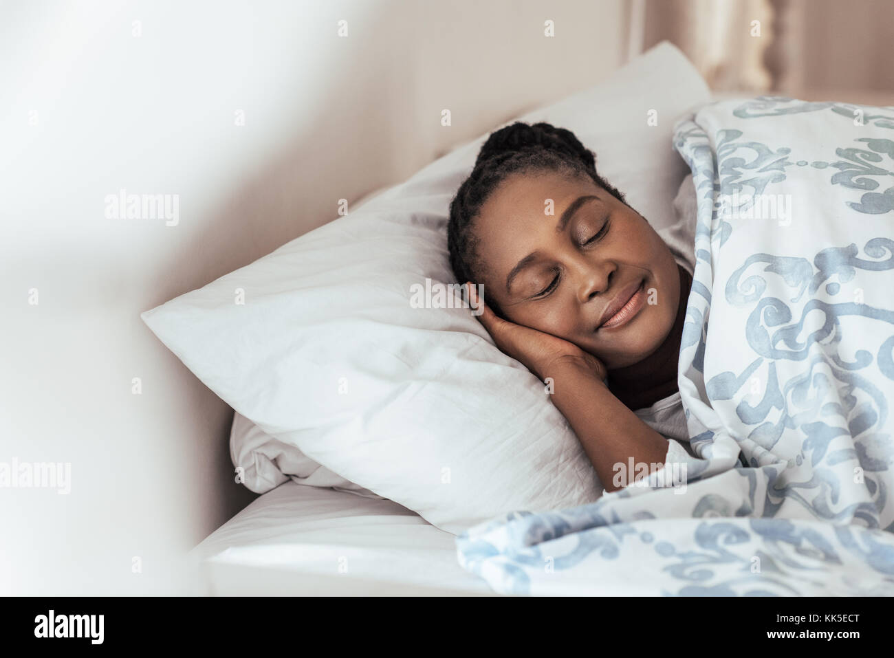 Giovane donna africana profondamente addormentato nel suo letto a casa Foto Stock