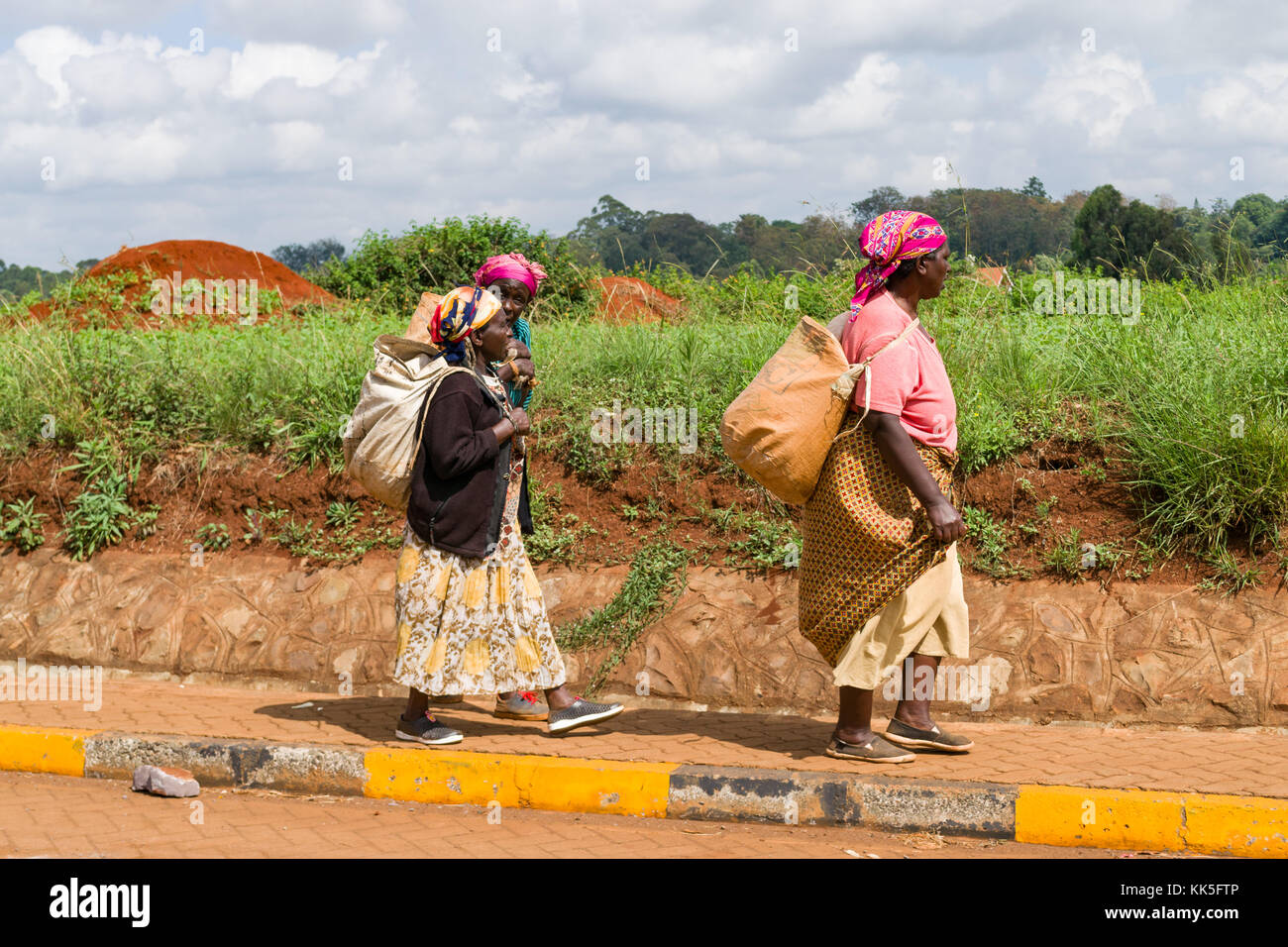 Tre persone anziane donne africane a piedi sul marciapiede borse e zaini nel sole di mezzogiorno, Nairobi, Kenia Foto Stock