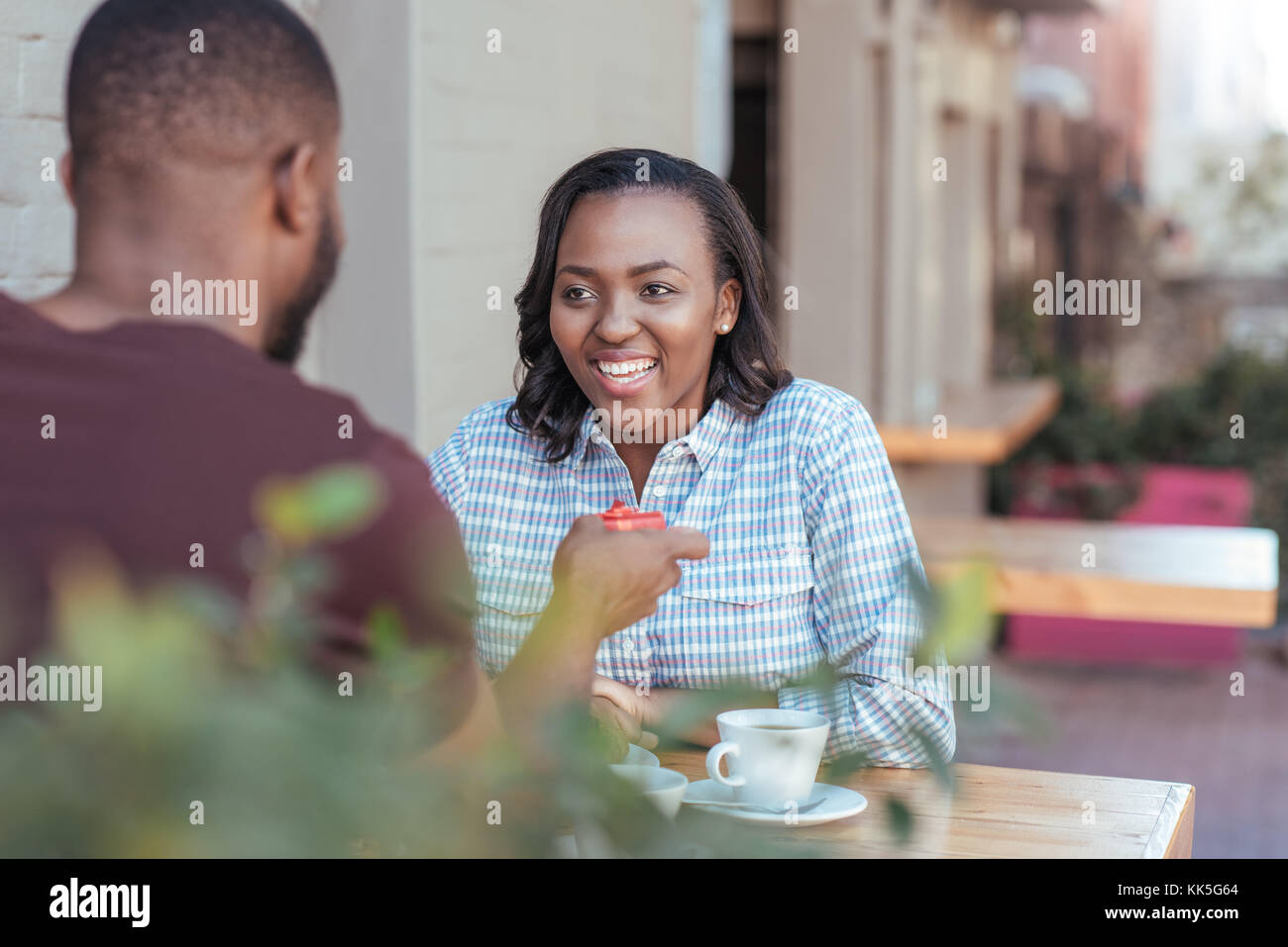 Sorridente giovane donna africana ottenendo un regalo dal suo fidanzato Foto Stock