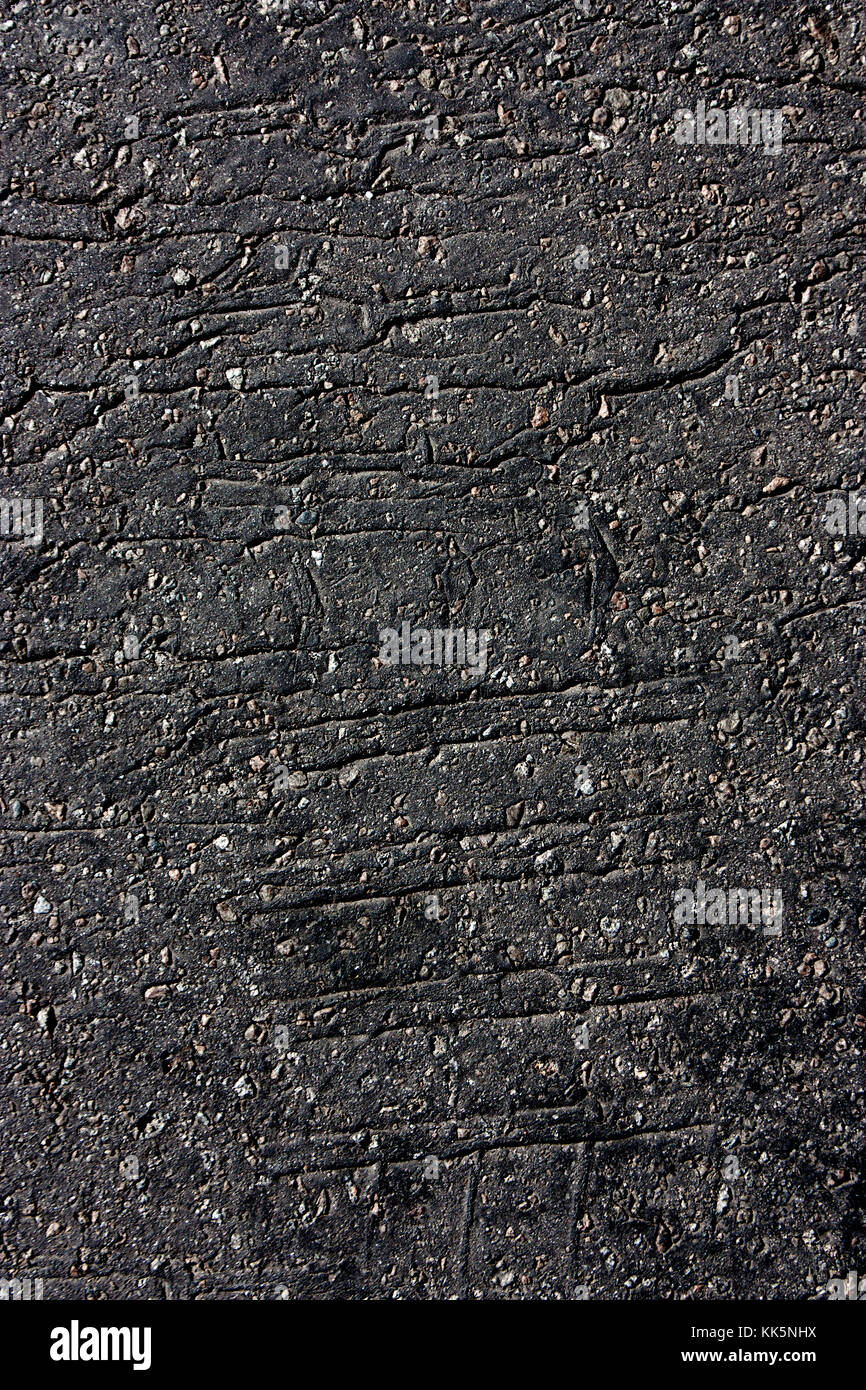 Pneumatico imprime sulla vecchia incrinato strada asfaltata in bianco e nero Foto Stock