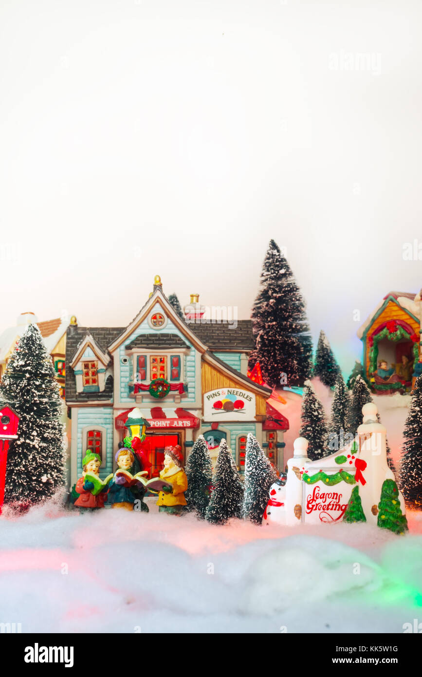 Kid coro gospel cantando accanto all seasons saluto in bianco Natale villaggio da fiaba di paesaggi in miniatura Foto Stock