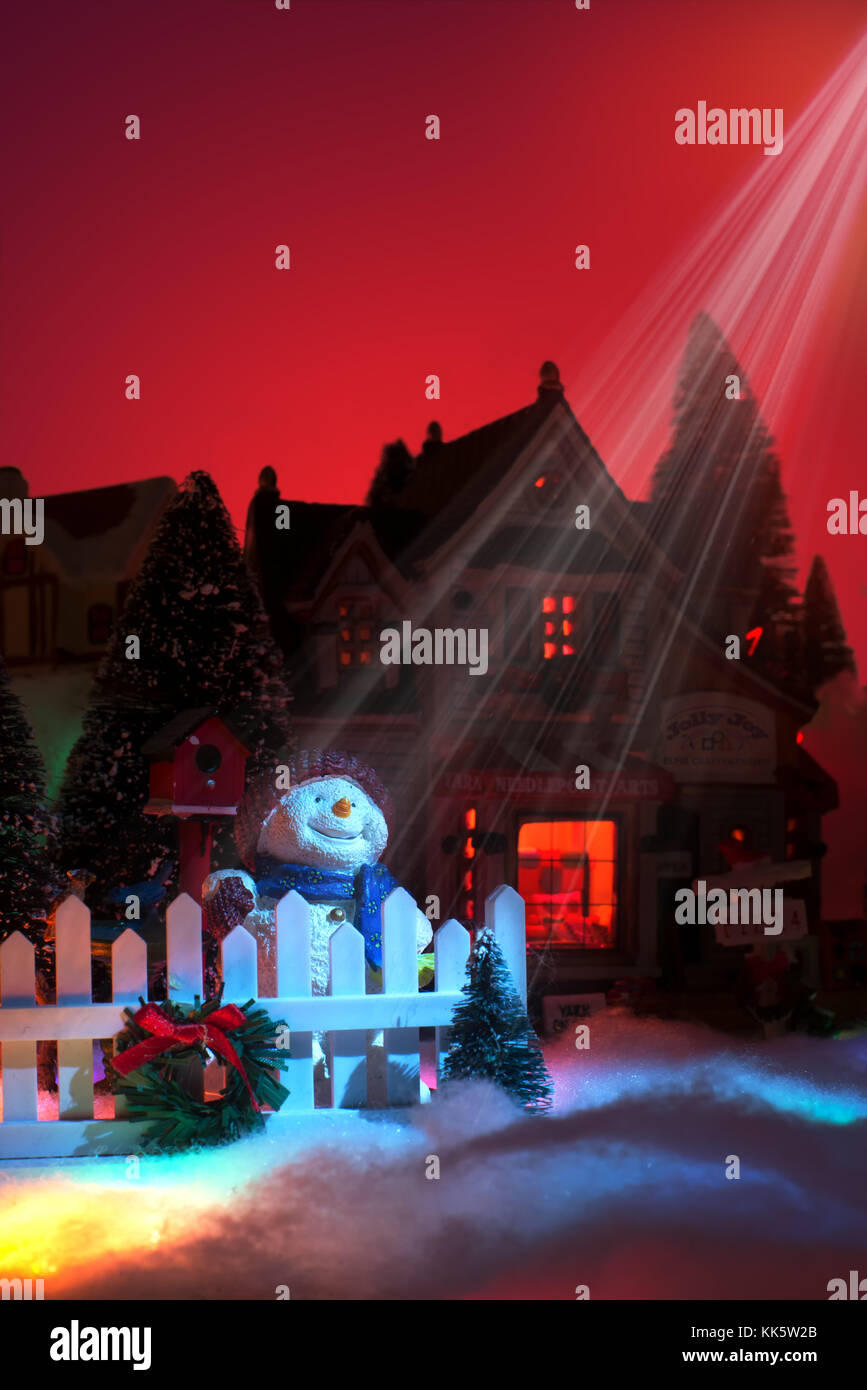 Stagioni saluto con sorridente pupazzo di neve si distingue per il natale decoratives recinto con le luci dalla stella di Betlemme splendenti sul suo volto felice. fai Foto Stock