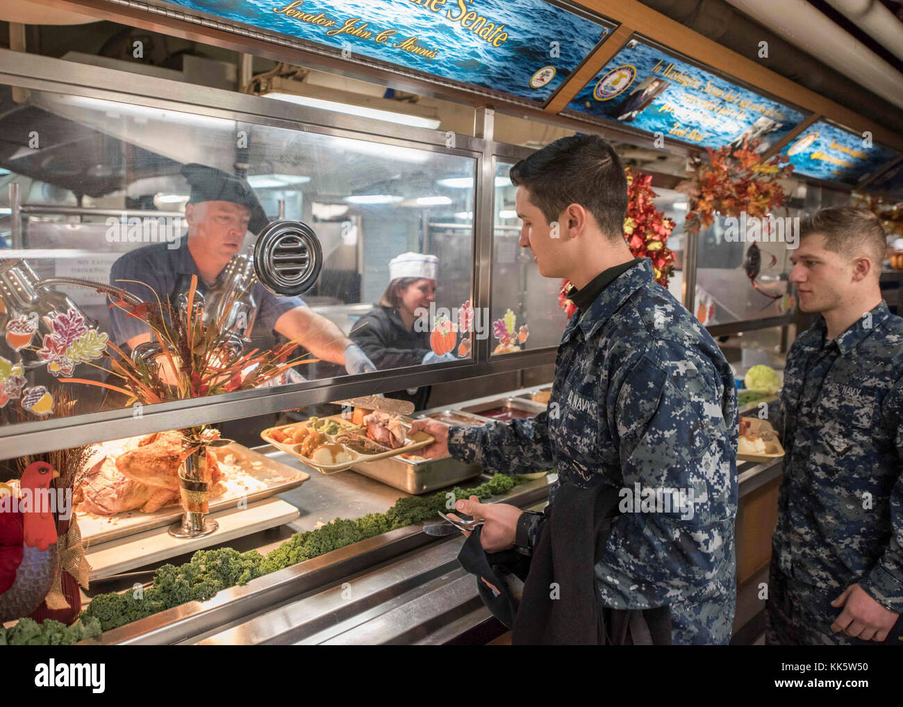 BREMERTON, Washington (novembre 23, 2017) CMdR. Kenneth Holland, responsabile tecnico USS John C. Stennis' (CVN 74), e il Lt. CMdR. Melissa Gonzales, l'assistente principale del reparto forniture per i servizi, serve la turchia ai marinai durante un pasto del giorno del Ringraziamento a bordo della nave. John C. Stennis sta conducendo una formazione di routine nel porto mentre continua a prepararsi per la sua prossima implementazione pianificata. (STATI UNITI Navy Photo by Mass Communication Specialist 3rd Class Jake Greenberg / released) Foto Stock