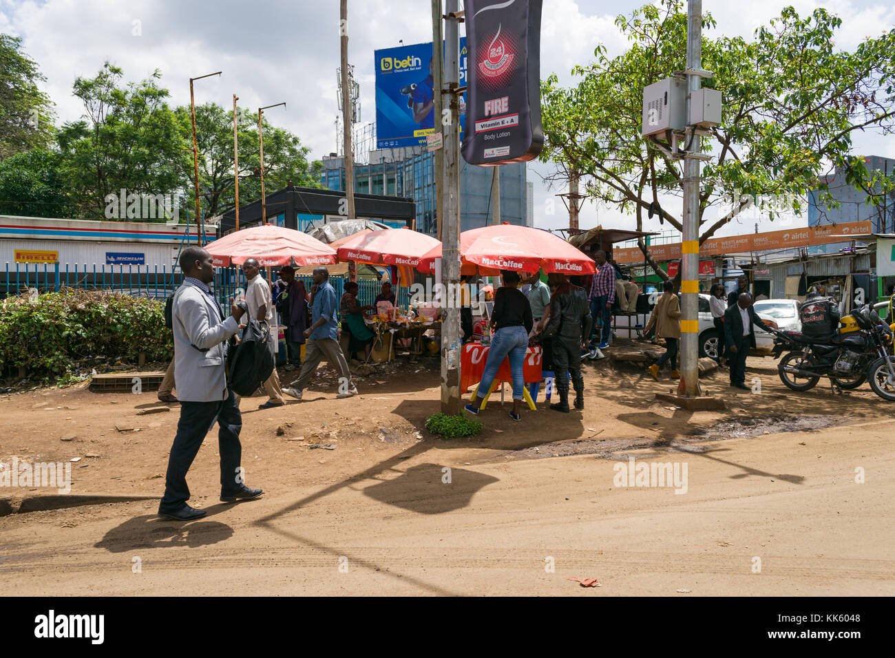 Tipica scena di strada di Nairobi con ombreggiato bancarelle che vendono merci e persone camminando sul marciapiede, Kenya, Africa orientale Foto Stock