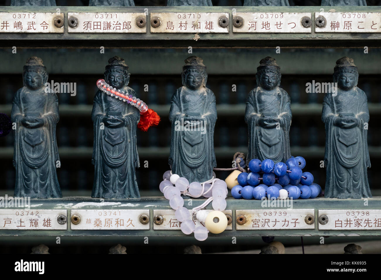 Nagano, Giappone - 3 giugno 2017: le righe del tradizionale di pietra scolpita miniatura statue buddiste con offerte presso il Tempio Zenkoji Foto Stock