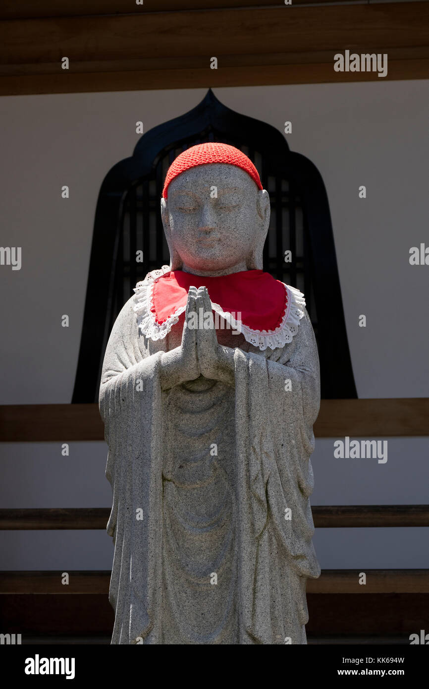 Nagano, Giappone - 5 giugno 2017: tradizionale di pietra scolpita jizo con mantello rosso e hat al tempio zenkoji Foto Stock