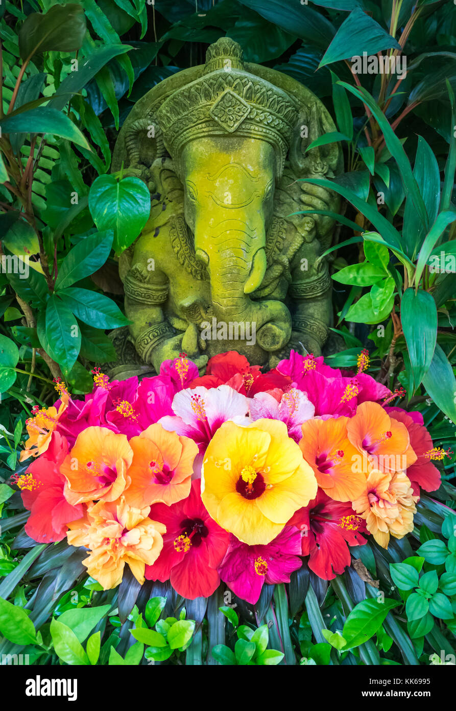 Ganesh statua di pietra con fiori di ibisco, Thailandia Foto Stock