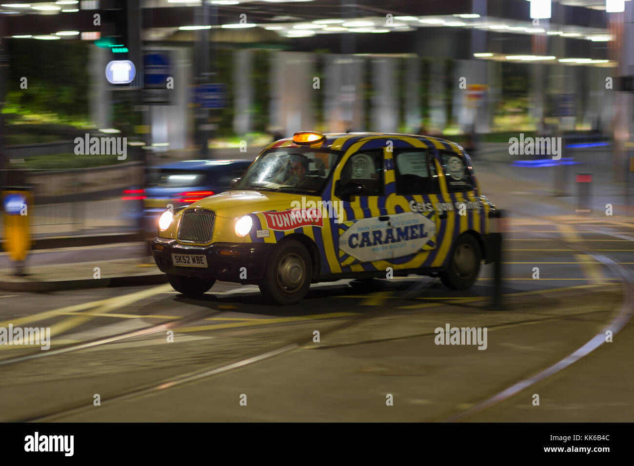 Taxi moderna cabina con pubblicità su di esso, Birmingham City Centre di notte REGNO UNITO Foto Stock