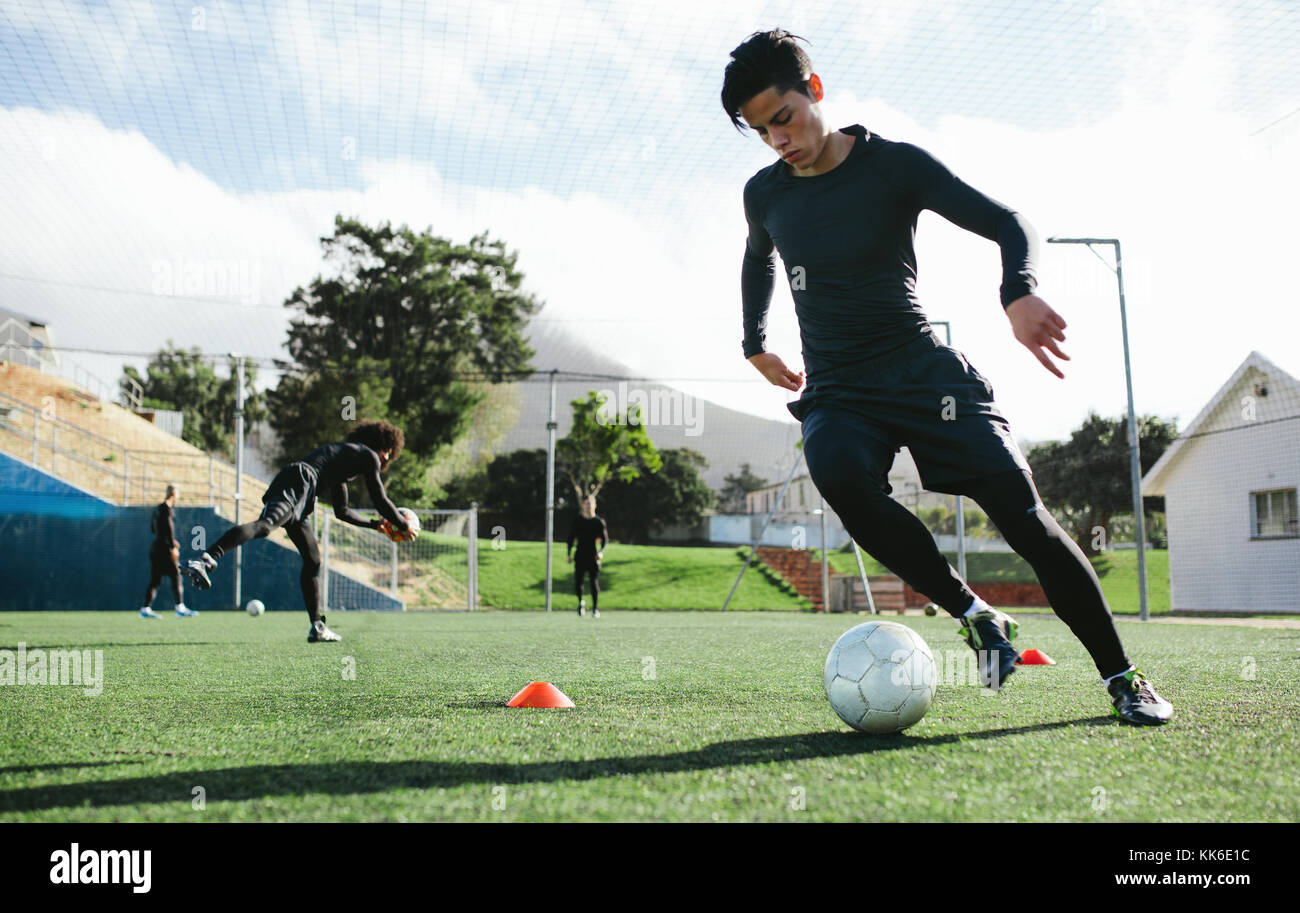Giocatore di calcio della formazione in campo di calcio. Giovane giocatore di calcio la pratica di controllo di palla sulla sessione di formazione. Foto Stock