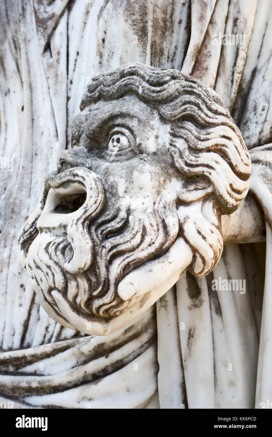 Una maschera tragica nella mano della statua di Melpomene : la musa della tragedia, sul palazzo Achillion, Corfu Grecia. Foto Stock