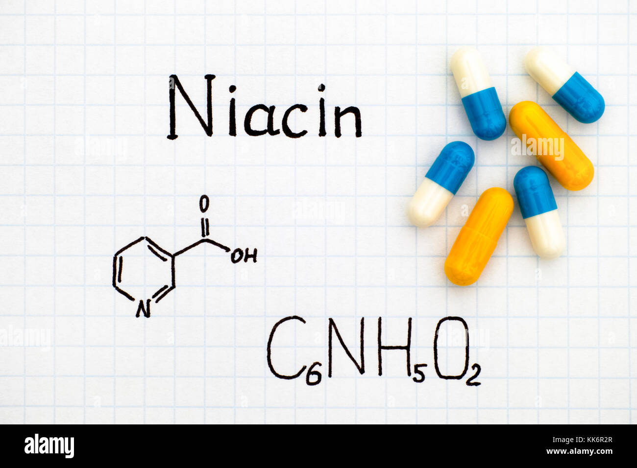 Formula chimica di niacina con alcune pillole. close-up. Foto Stock