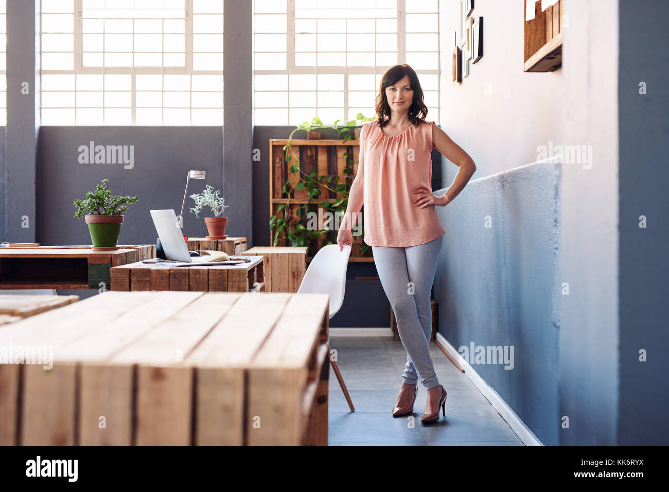 Fiducioso giovane imprenditrice in piedi da solo in un ufficio moderno Foto Stock