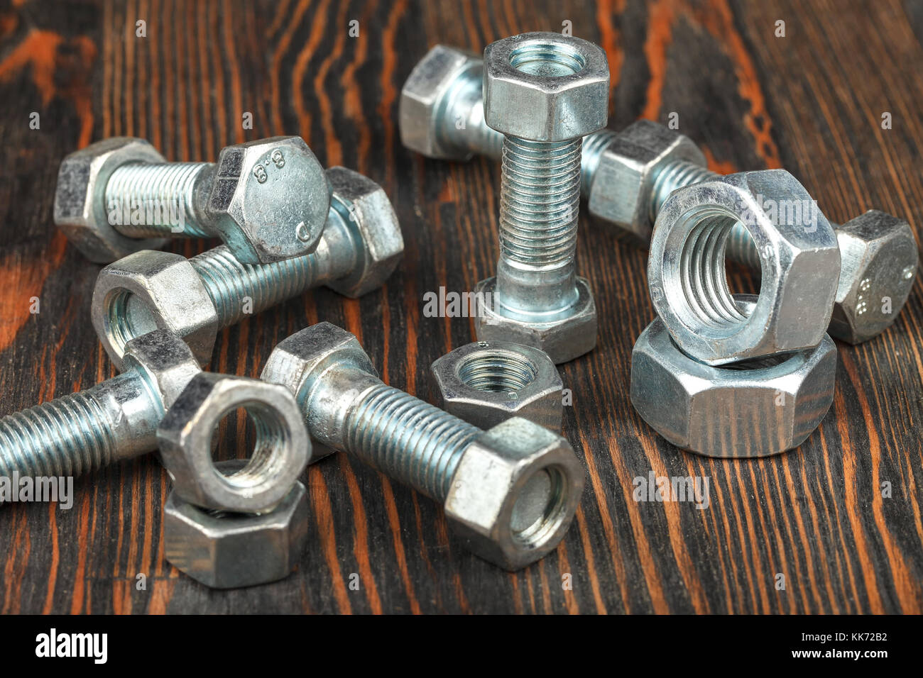 Le viti e i dadi su una superficie in legno. close-up. studio di illuminazione. Foto Stock
