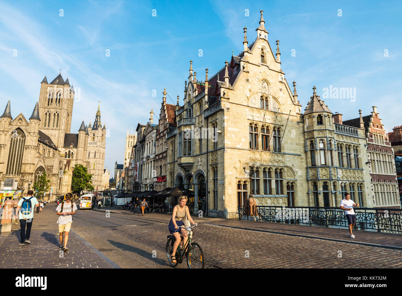 Ghent, Belgio - 28 agosto 2017: facciata del la chiesa di San Nicola e la torre campanaria con la gente a piedi e in bicicletta nel centro storico della città medievale Foto Stock