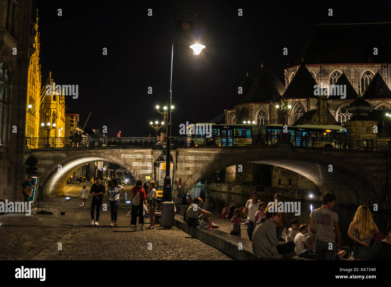 Ghent, Belgio - 28 agosto 2017: persone divertirsi la notte accanto al fiume nella città medievale di Gent, Belgio Foto Stock