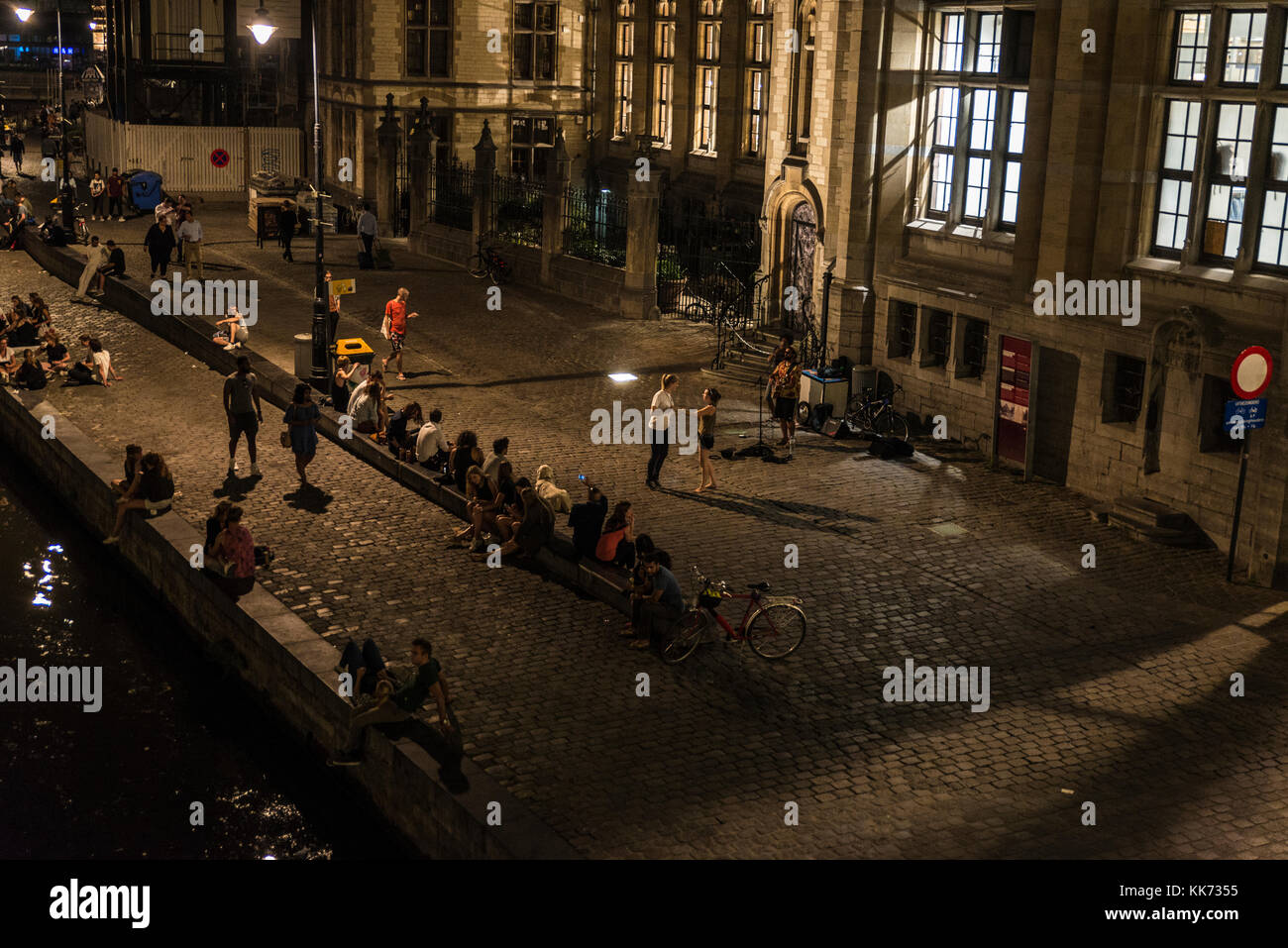 Ghent, Belgio - 28 agosto 2017: persone divertirsi la notte accanto al fiume nella città medievale di Gent, Belgio Foto Stock