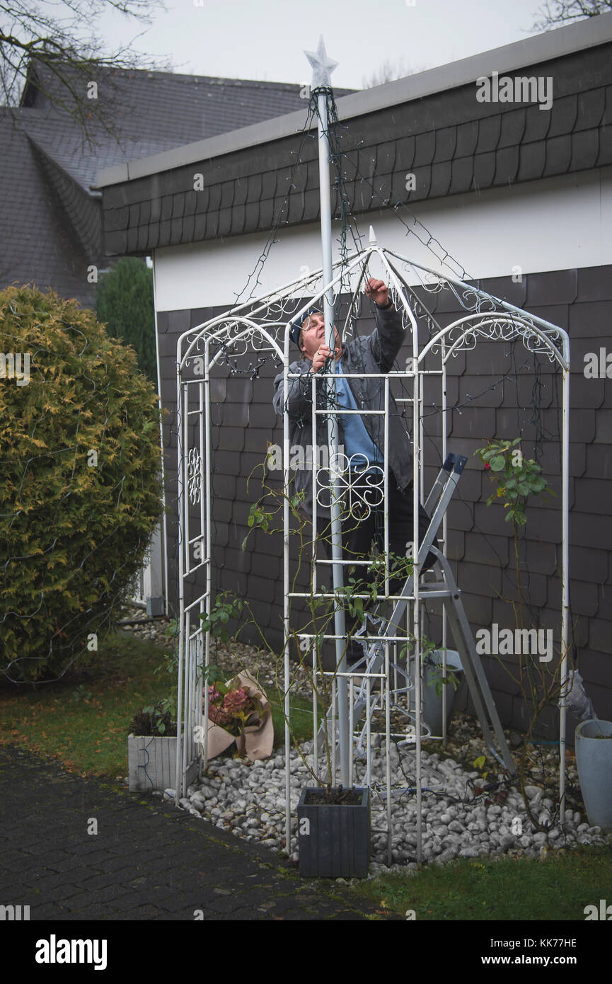 Tempo di Avvento e di natale - la catena di luci sono installati nel giardino, anche se piove Foto Stock