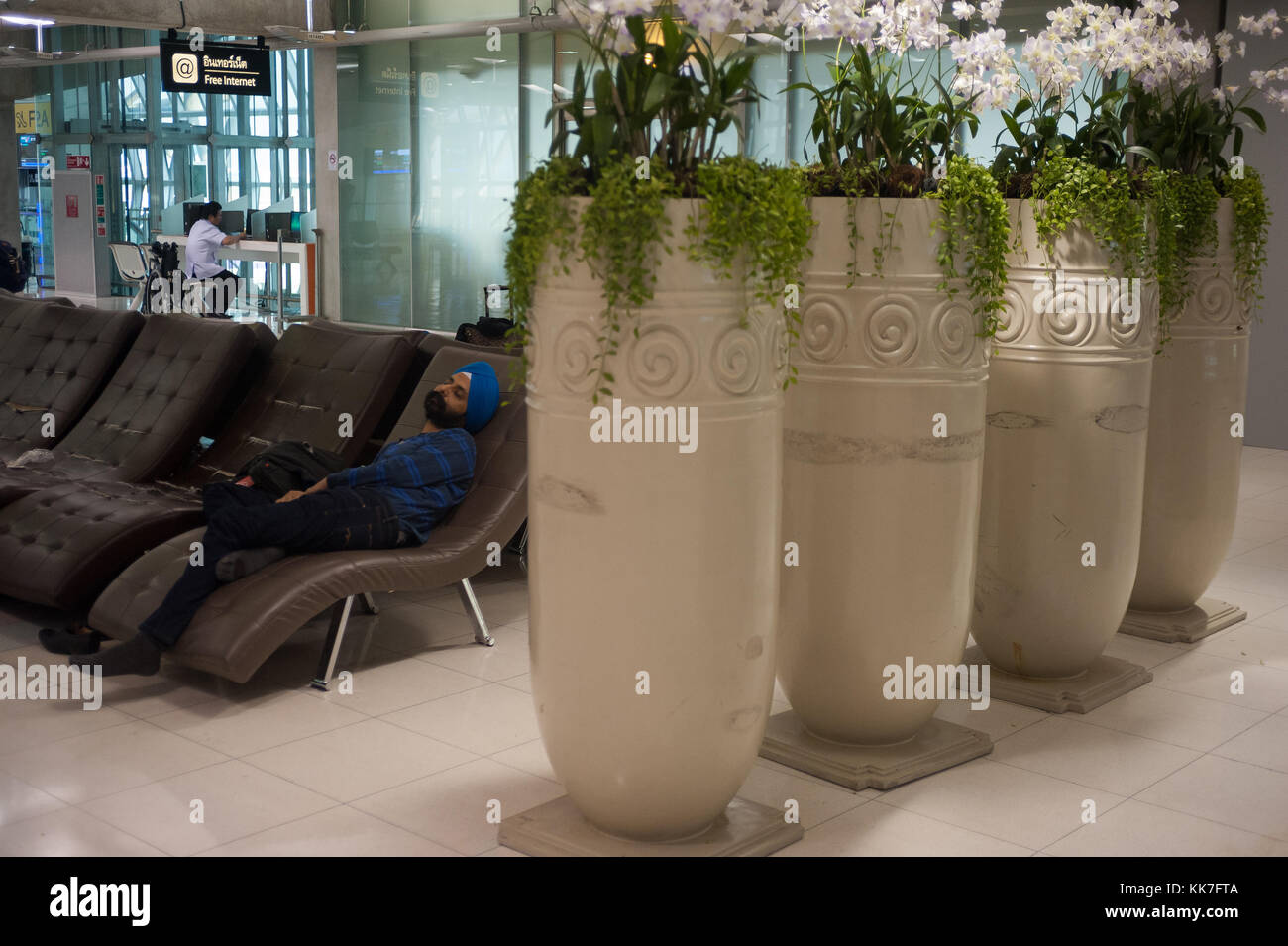 Bangkok, Thailandia, passeggero dorme nella zona di partenza all'aeroporto di Bangkok Foto Stock
