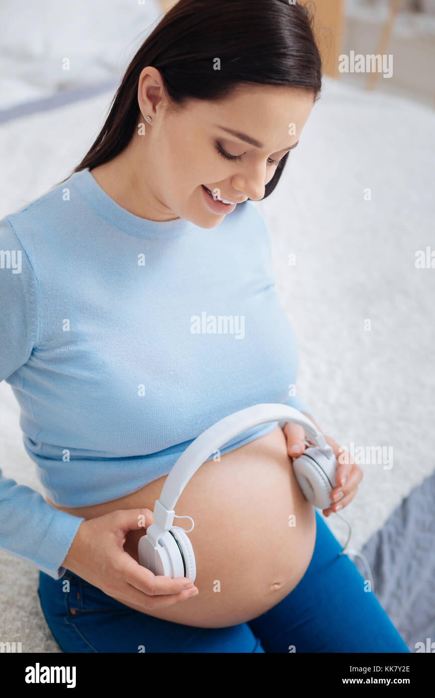 Affascinante ragazza guardando il suo bambino pancia Foto Stock